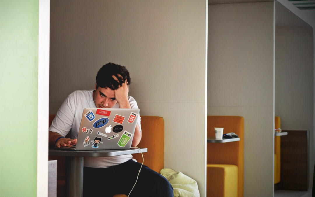Die 4 nervigsten Word Probleme und ihre Lösungen. Bild zeigt einen Mann in einem Café der an seinem Laptop arbeitet