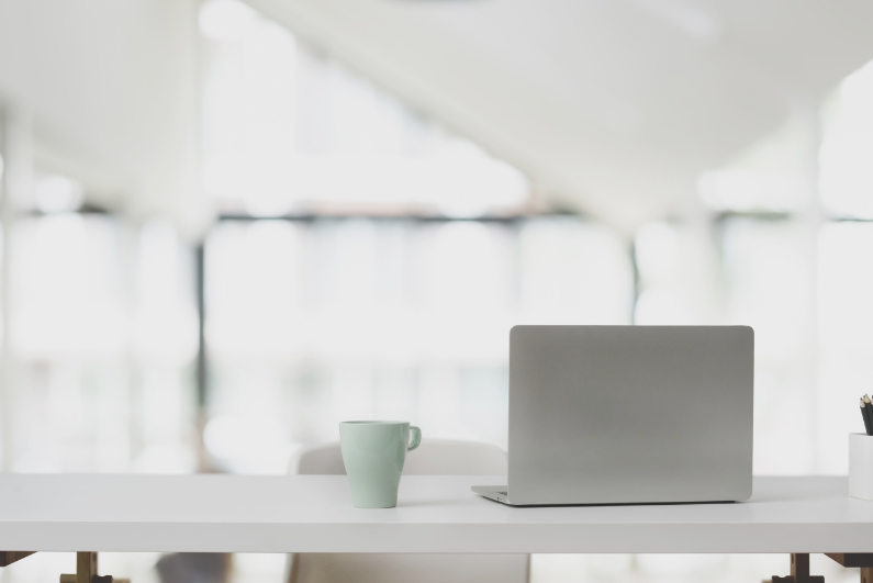 Schreibtisch mit Tasse, Notebook und Stiften